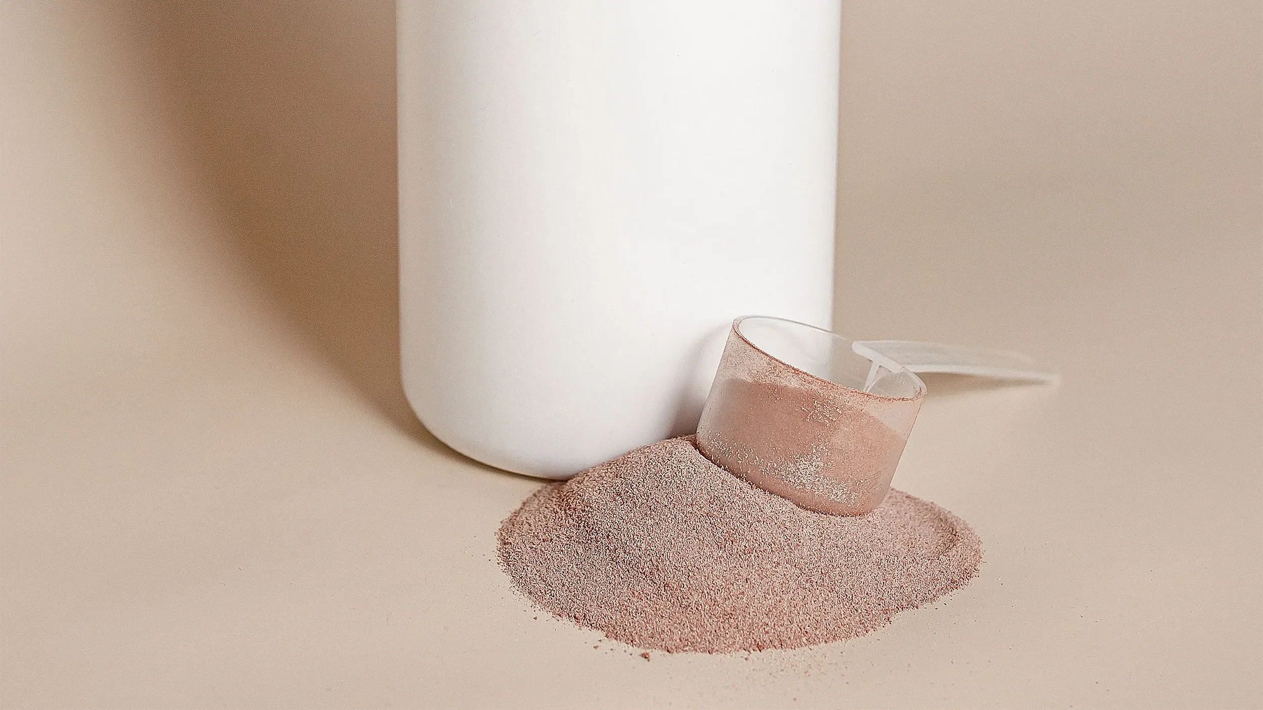 Scoop of prebiotic fiber powder next to chicory root and a glass of water, showing the prebiotics found in the best gut health supplements.