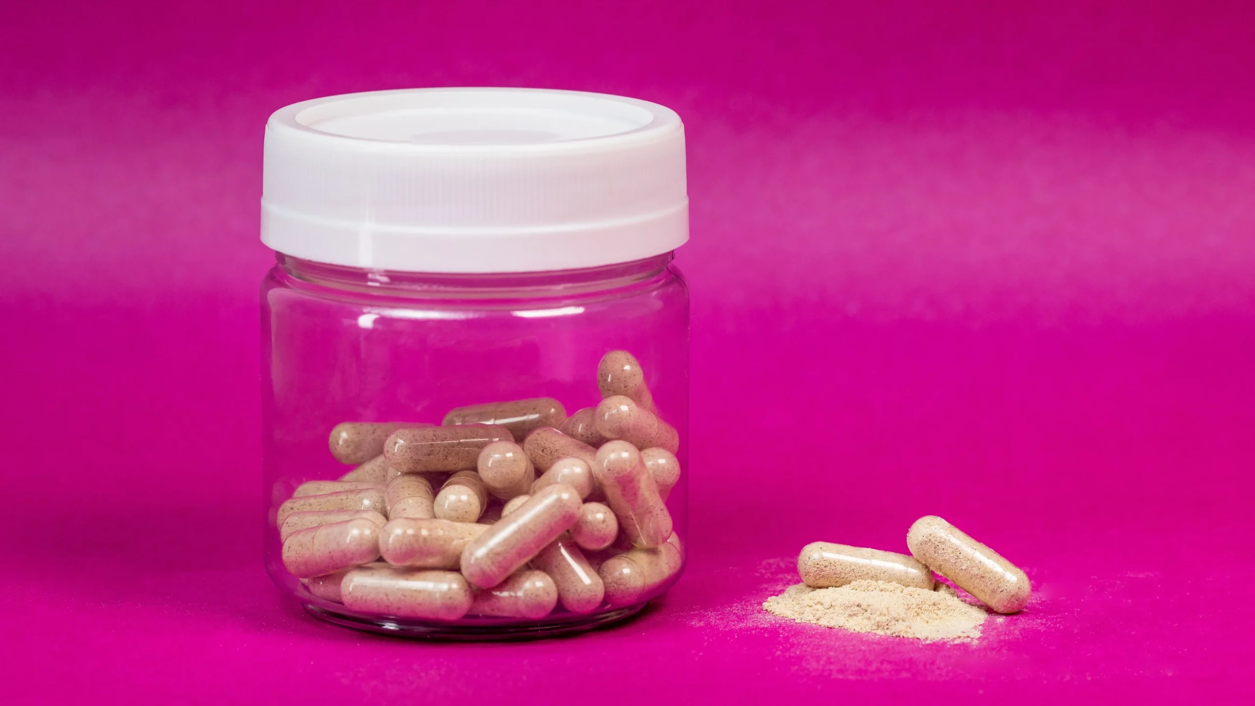 Open probiotic supplement bottle with capsules spilling out, highlighting the CFU count and strains that make the best gut health supplements effective.