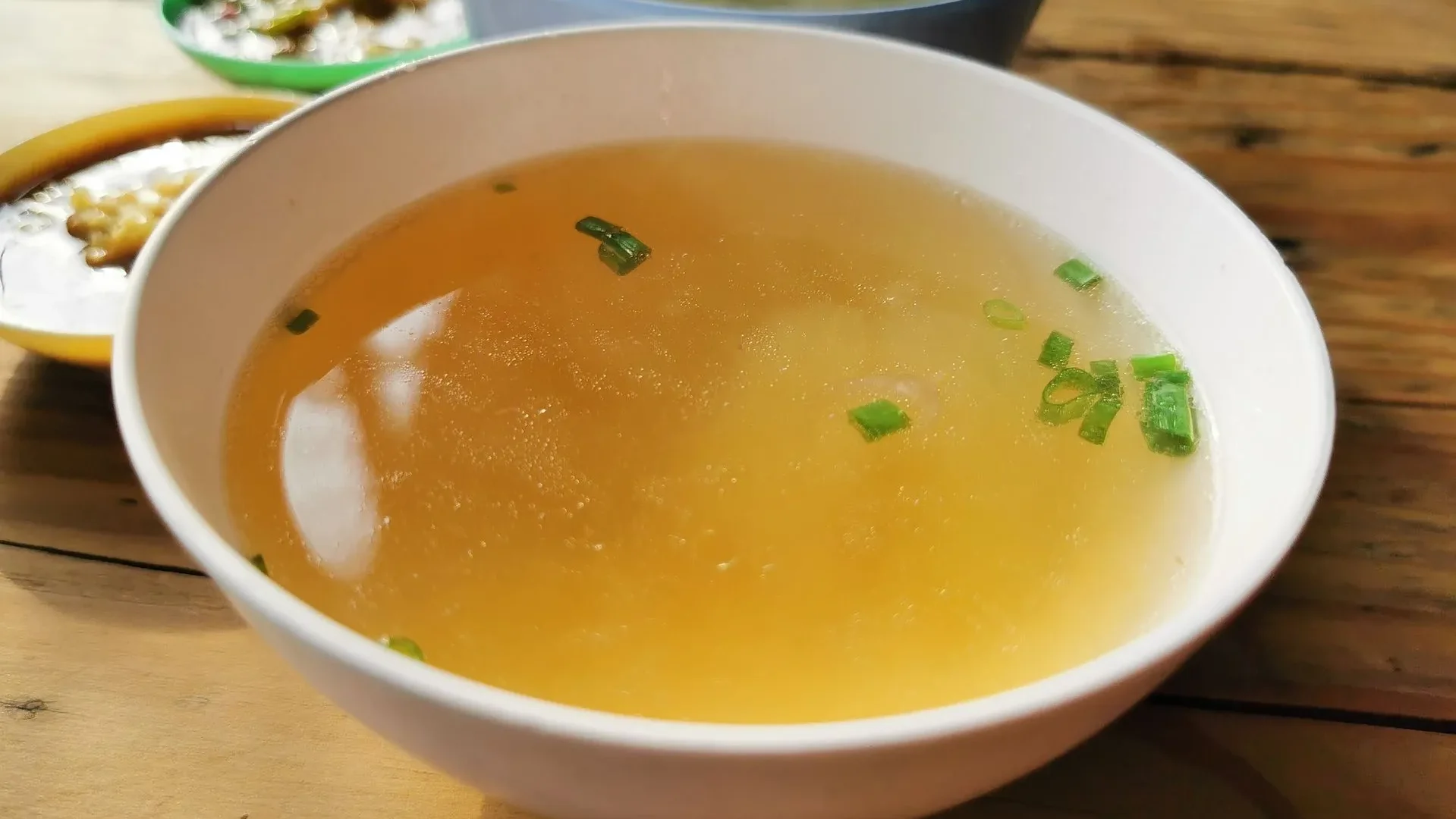 Cup of bone broth and a glass with dissolved collagen peptides, gut-supporting drinks for gut health that help maintain intestinal lining integrity.