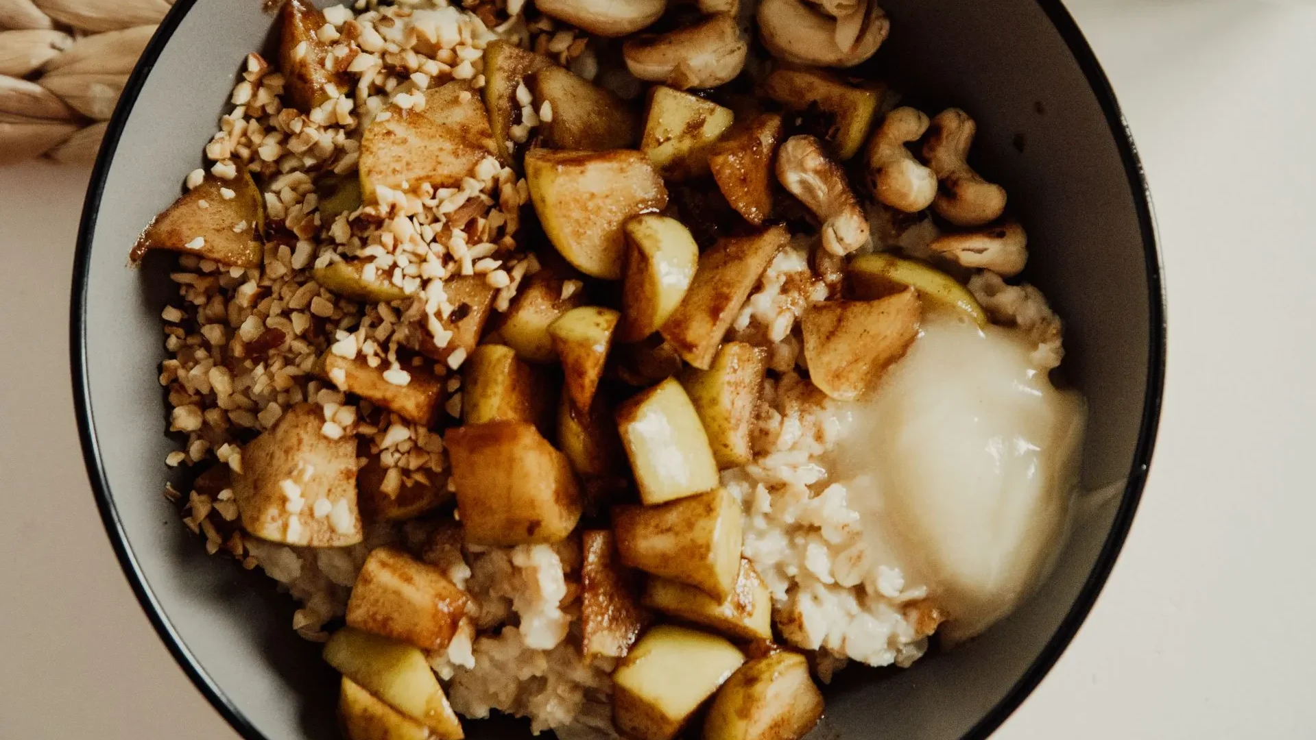 Stewed apples served alongside yogurt and a small dish of sauerkraut, pairing prebiotic-rich stewed apples for gut health with probiotic fermented foods.