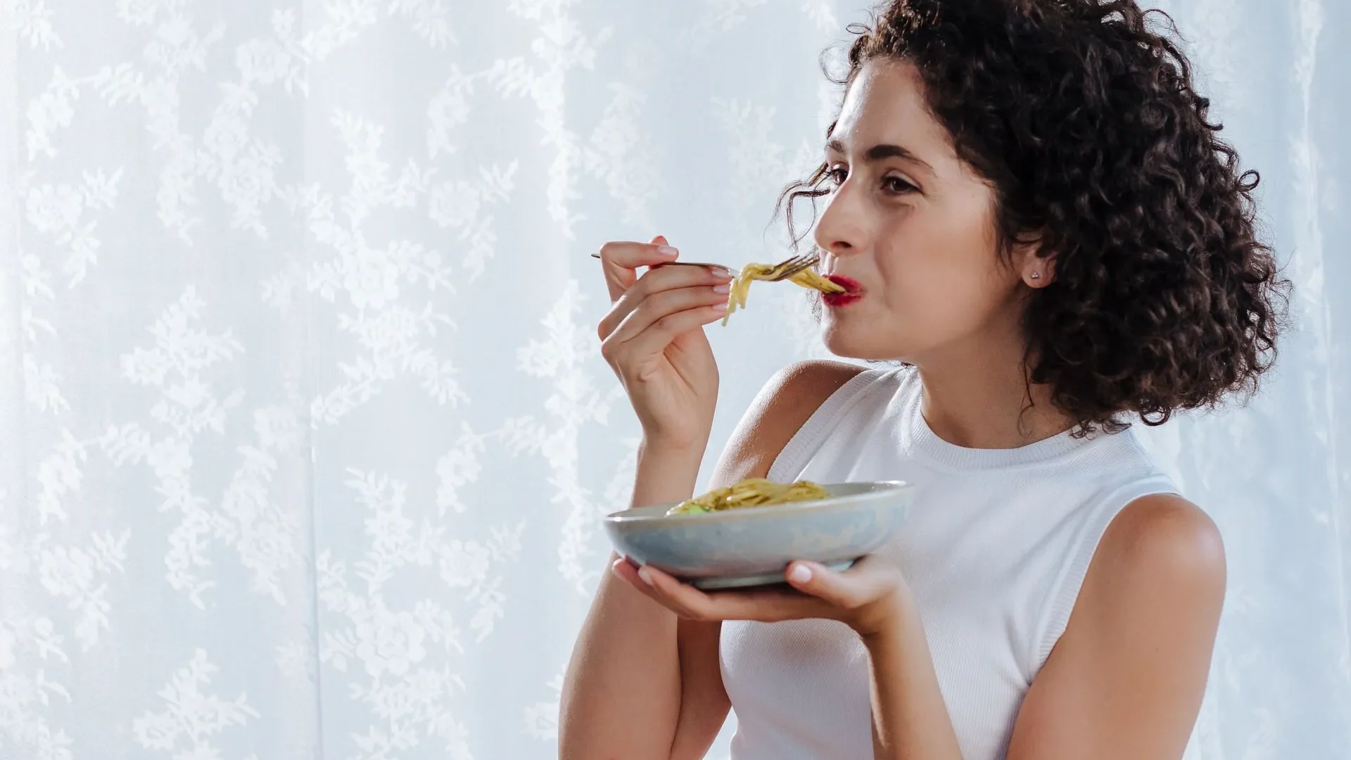 Person smiling and tasting a spoonful of homemade sauerkraut, concluding a beginner’s journey into what is fermented food and its lifelong benefits