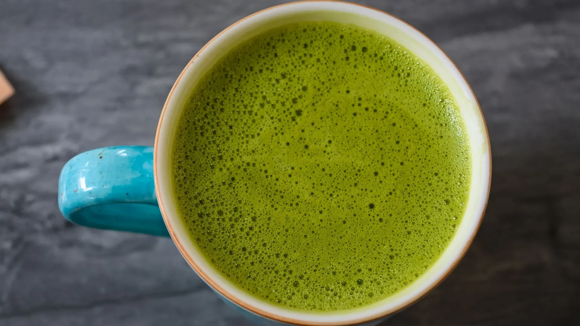  A steaming cup of green tea and matcha powder, a polyphenol-rich drink for gut health that feeds beneficial bacteria and reduces inflammation.