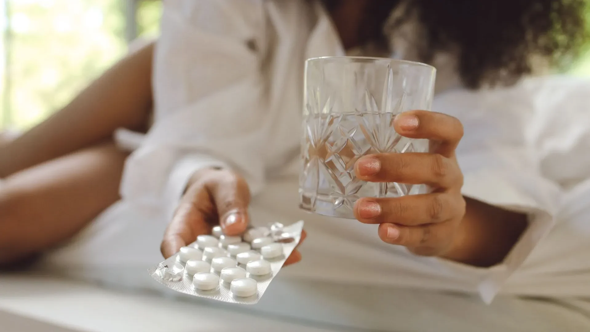 Scoop of collagen peptides being stirred into a glass of water, demonstrating how to use peptides for gut health consistently for best results.