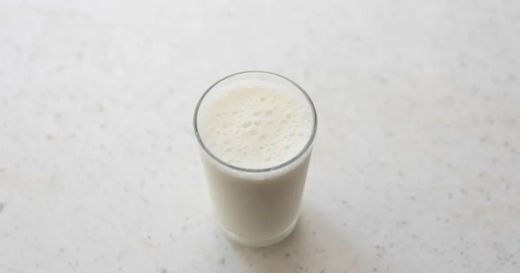 A glass of kefir next to a bowl of yogurt, highlighting the kefir benefits for gut health and the question of whether kefir is better than yogurt.