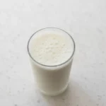 A glass of kefir next to a bowl of yogurt, highlighting the kefir benefits for gut health and the question of whether kefir is better than yogurt.