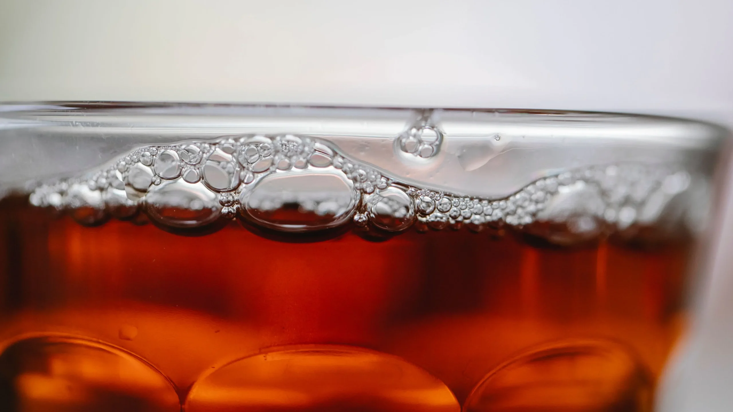  A glass of kombucha next to a bottle and a SCOBY, one of the best probiotic drinks with beneficial bacteria and organic acids.