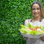 Person smiling and holding a bowl of colorful vegetables and fermented foods, ready to start improving their gut health naturally.