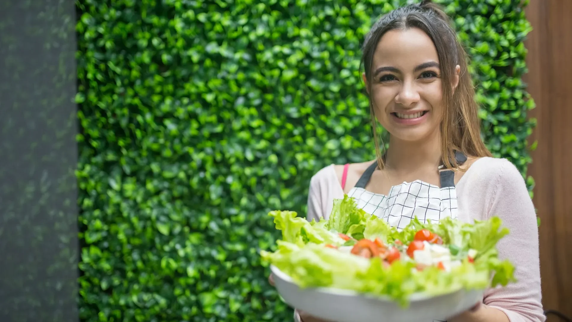 Person smiling and holding a bowl of colorful vegetables and fermented foods, ready to start improving their gut health naturally.
