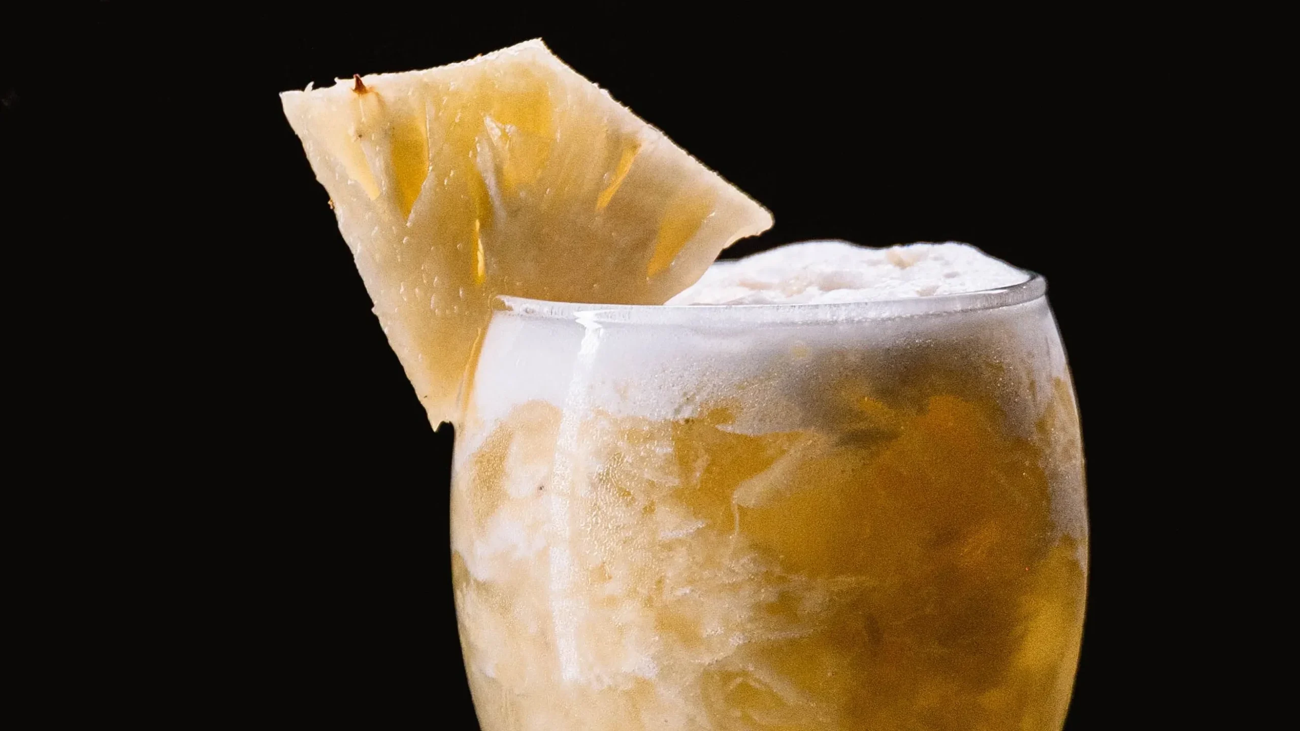 Mexican tepache served in a glass with pineapple and cinnamon sticks, a traditional fermented option among the best probiotic drinks.