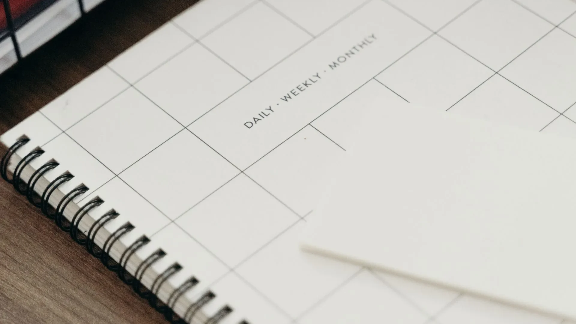 Digital tablet and planner showing a weekly overview, with a pen and a cup of tea, symbolizing reflection on gut-friendly habits.