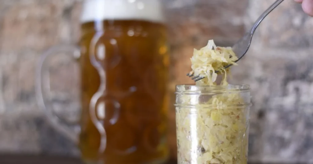 Collage of popular fermented foods—sauerkraut, kimchi, kombucha, kefir, miso, and tempeh—illustrating the simple answer to what is a fermented food with varied examples.