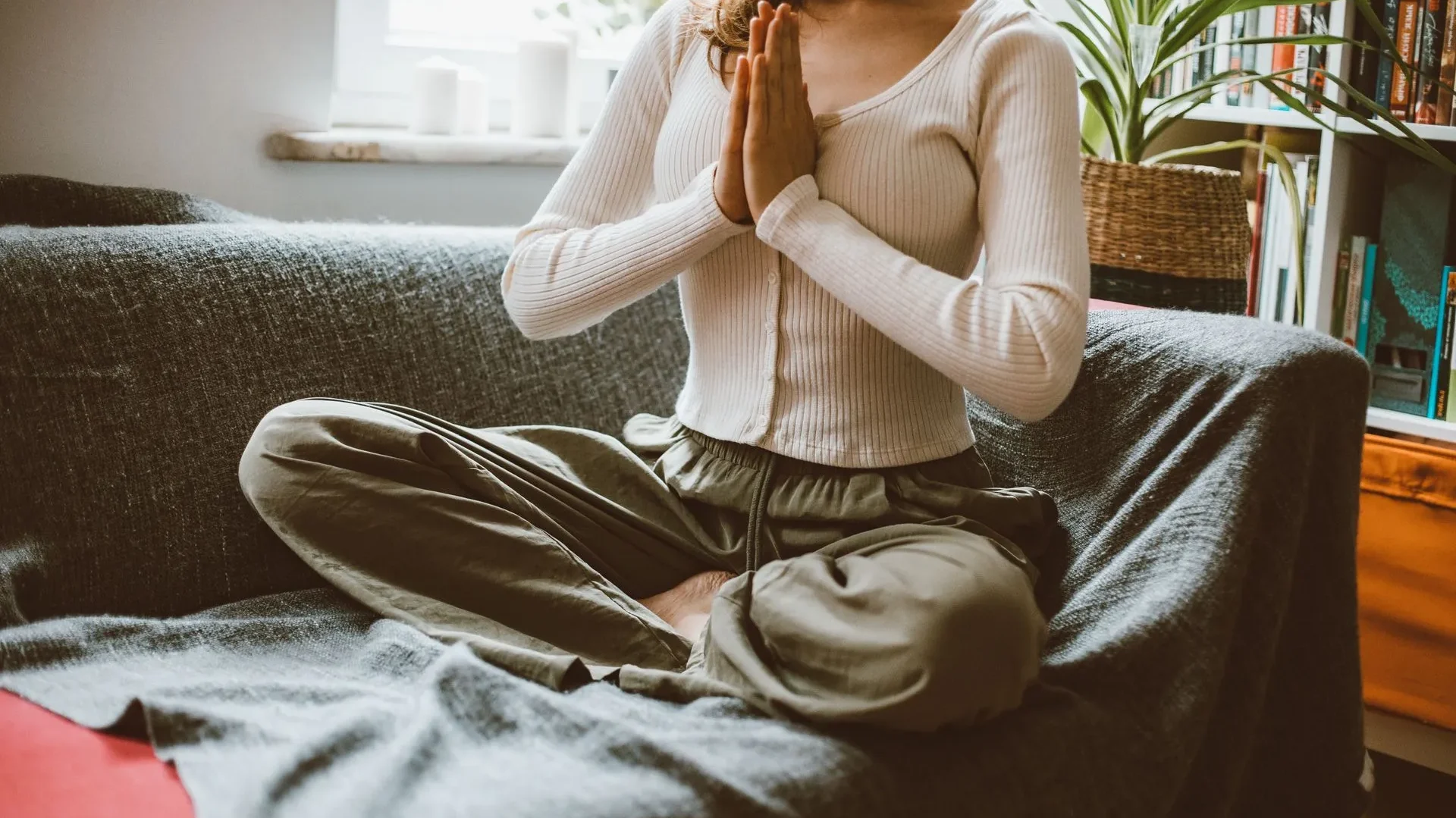 Woman meditating in a calm living room with soft lighting, practicing deep breathing to support the gut-brain axis and digestion.