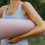 Woman practicing a seated spinal twist on a yoga mat, representing a yoga for gut health sequence that aids digestion.