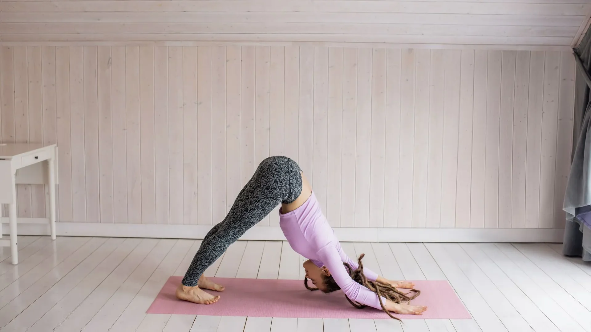  Person in Downward-Facing Dog pose, an inversion used in yoga for gut health to improve blood flow to digestive organs and ease constipation.