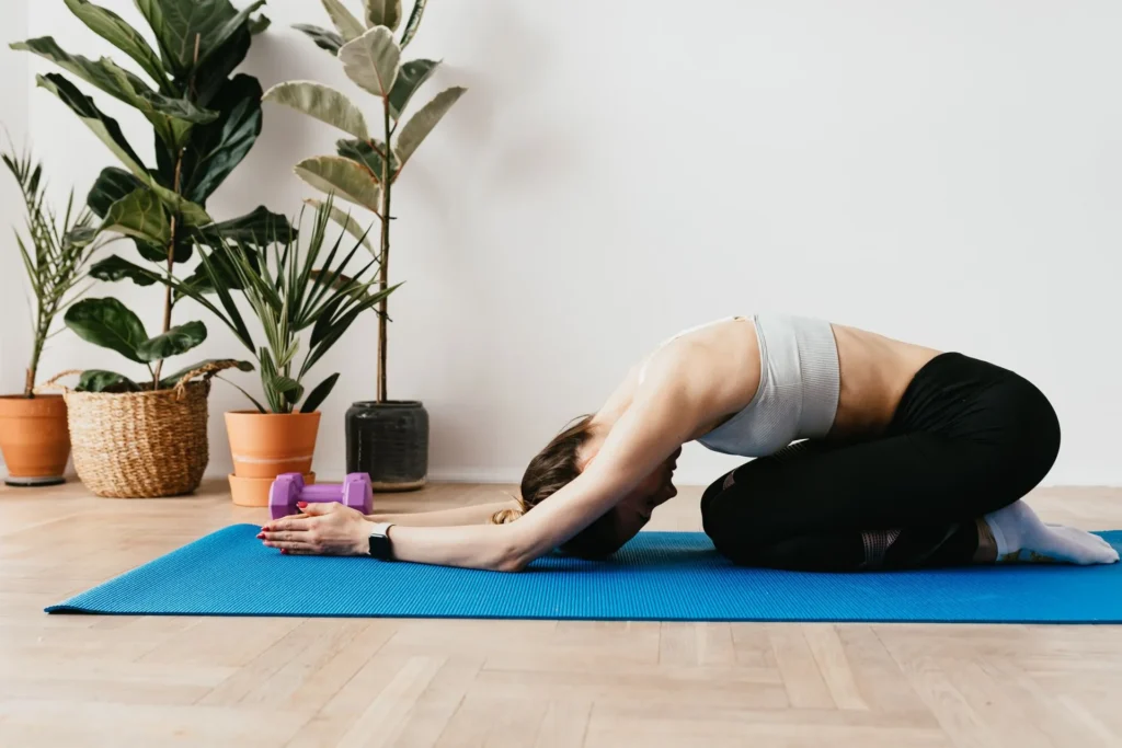 Person following a yoga for gut health routine on a mat, moving through poses like Downward Dog and Child's Pose to build a daily digestion practice