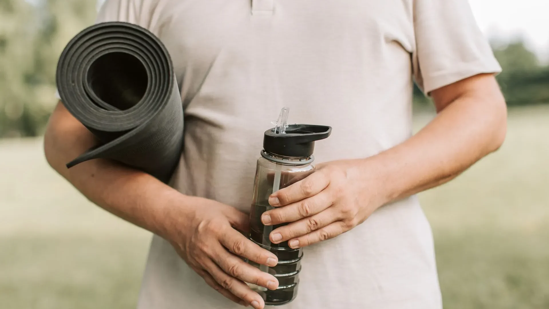  Woman drinking water next to her yoga mat, demonstrating the hydration and mindful breathing tips that enhance yoga for gut health results.