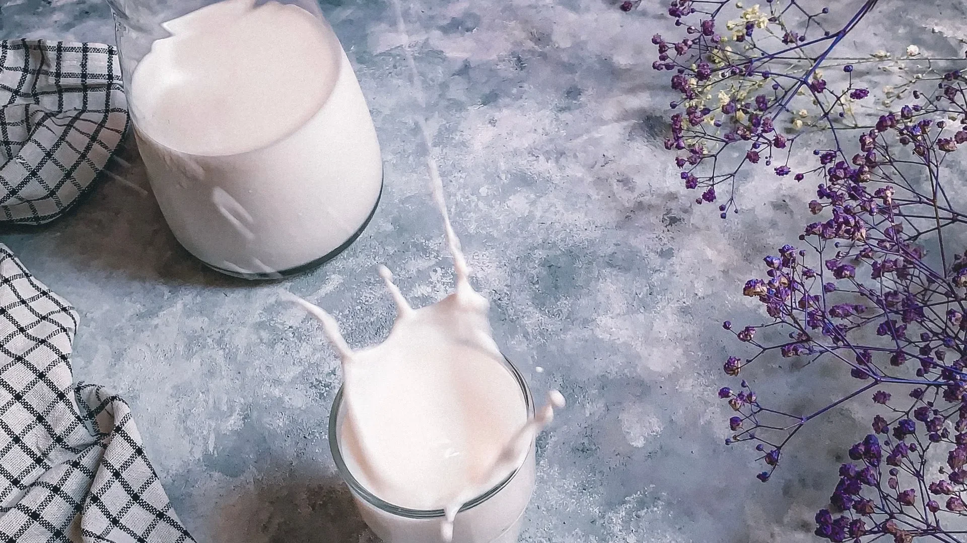 Icons of immune cells, bones, brain, and anti-inflammatory symbols around a glass of kefir, showing how kefir benefits for gut health extend to the whole body.