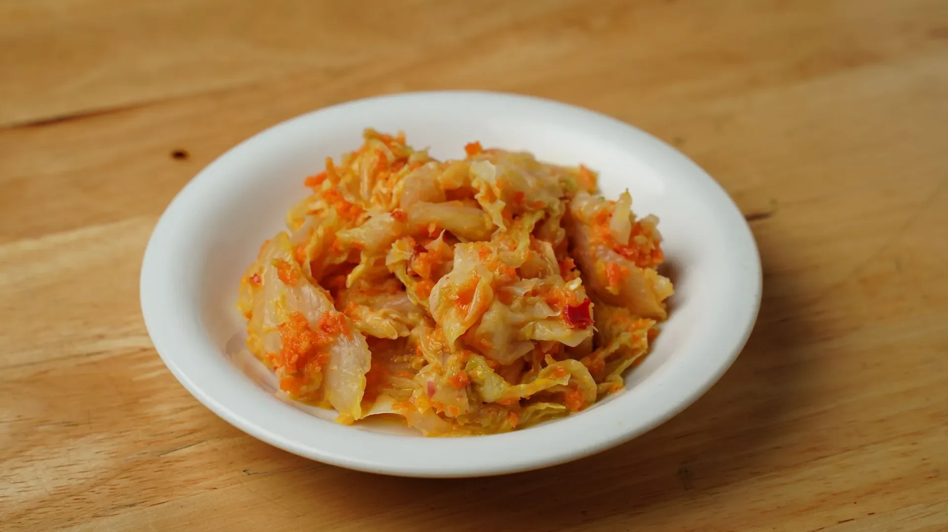 Diagram of the gut lining with anti-inflammatory signals and immune cells, linked to a bowl of kimchi, showing how daily kimchi benefits for gut health fight inflammation and support immunity.