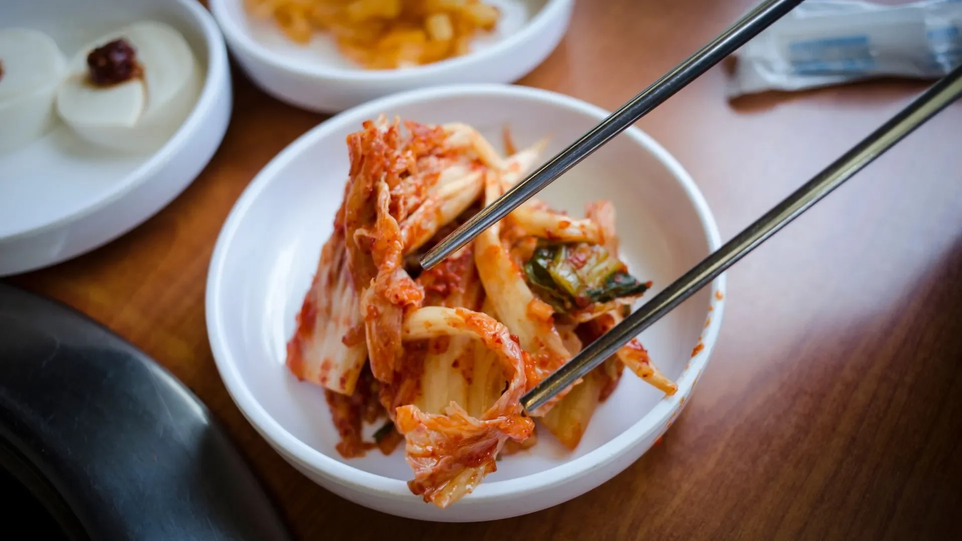 Illustration of a healthy gut with probiotic bacteria icons surrounding foods like yogurt and kimchi, highlighting why what is a fermented food matters for wellness.