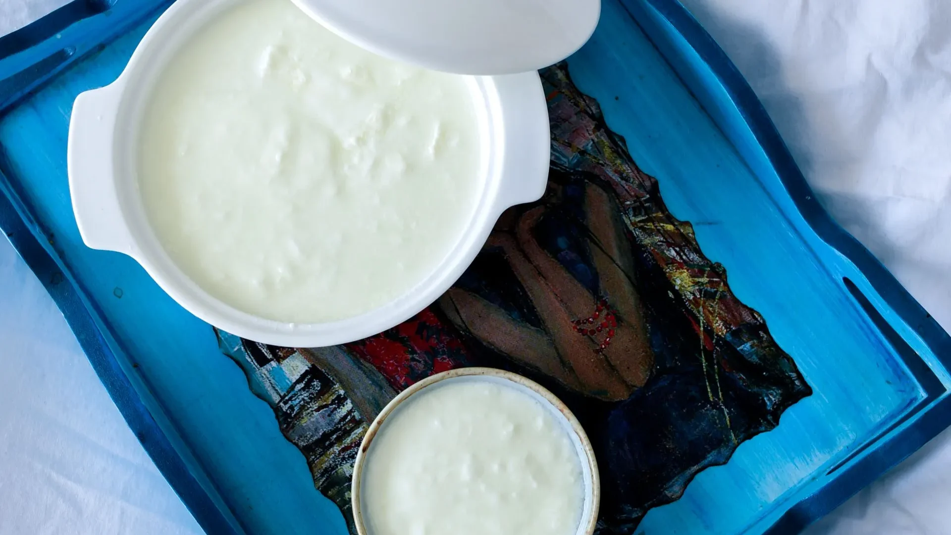 Two yogurt containers side by side, one with a simple ingredient list and "live cultures" label, illustrating how to select yogurt for maximum yogurt benefits for gut health.