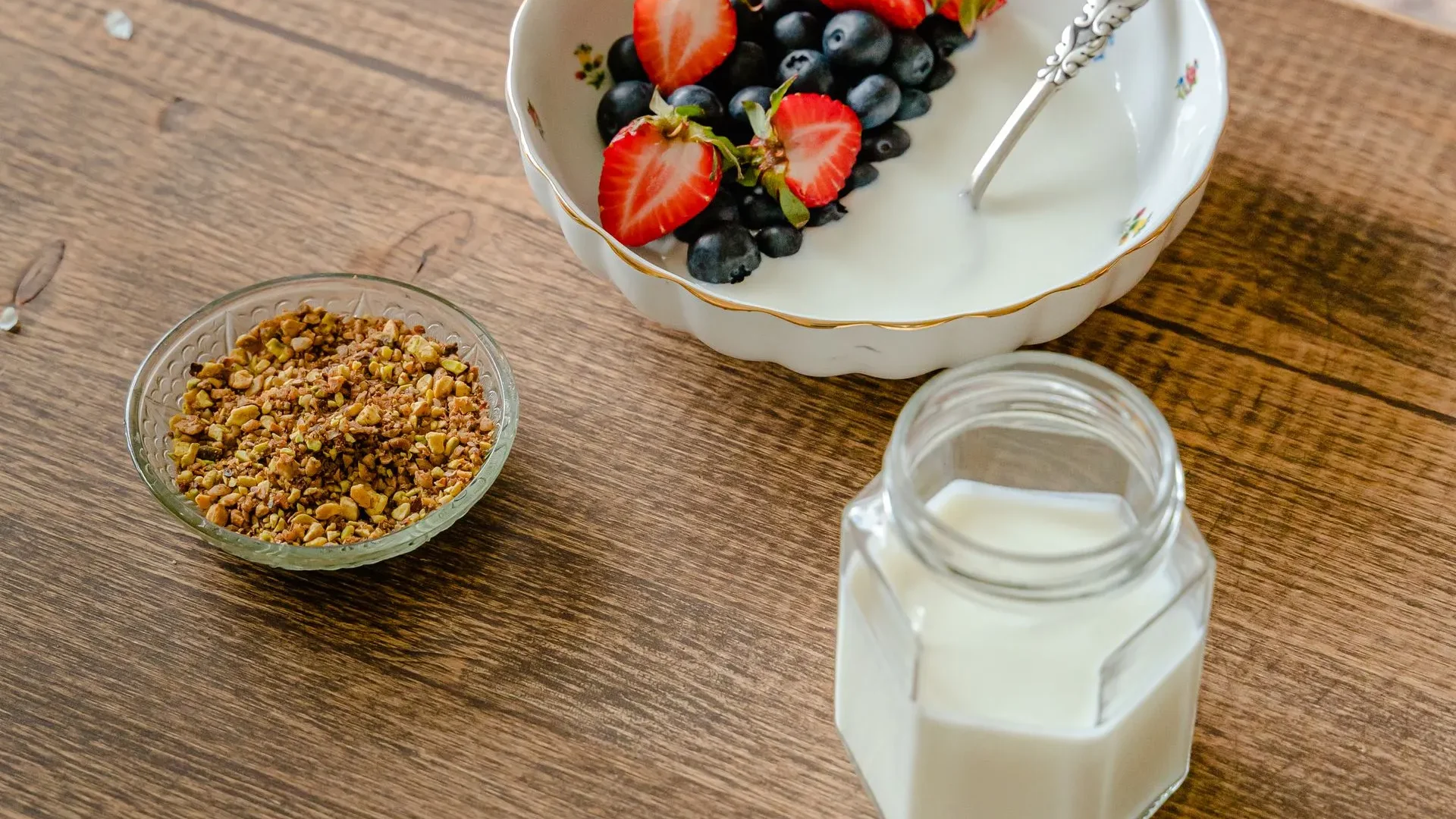 Side-by-side comparison of a glass of kefir and a bowl of yogurt with a chart of probiotic strains, CFU count, and lactose content, examining kefir benefits for gut health versus yogurt.