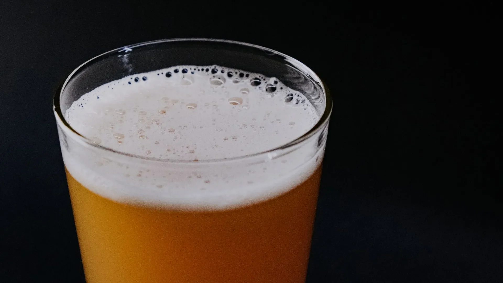 Glass jar of kombucha brewing with a SCOBY floating on top, explaining how the fermented tea is made and the foundation of kombucha benefits for gut health.