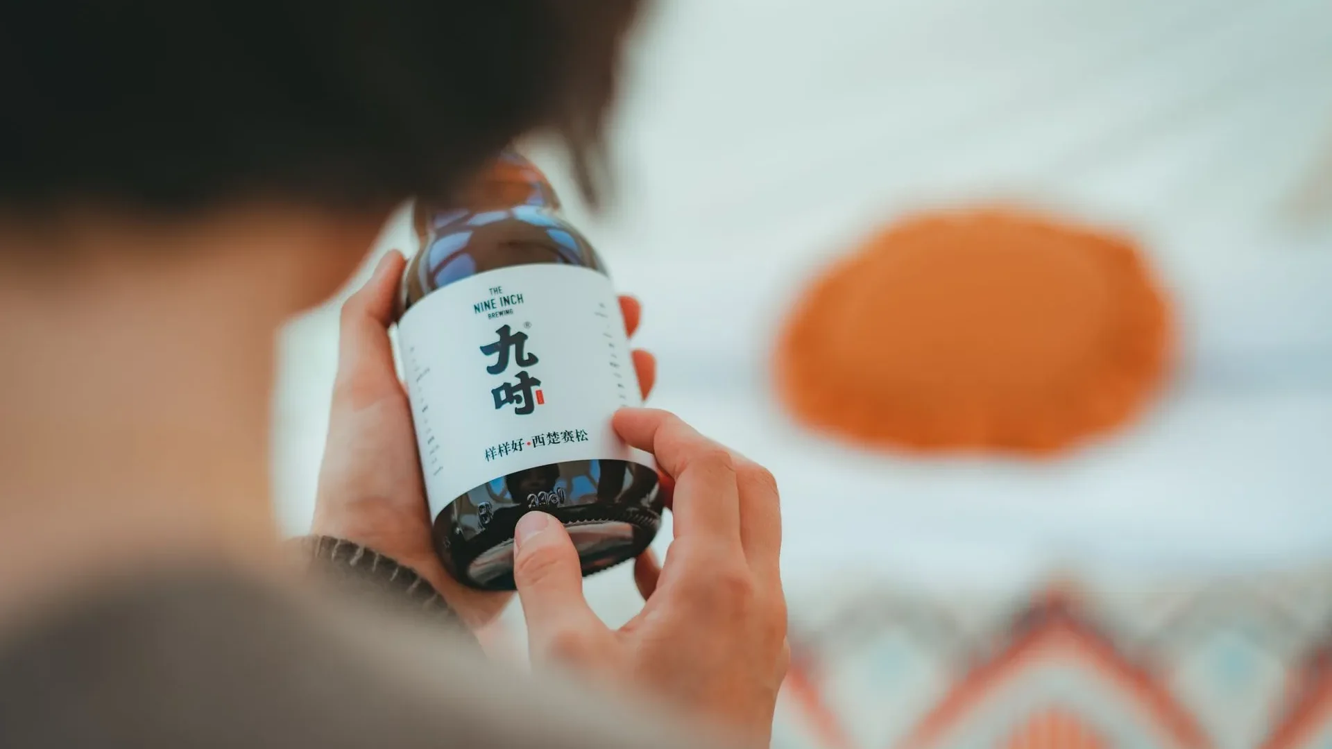Hand picking up a bottle of unpasteurized kombucha with low sugar from a store shelf, showing how to maximize kombucha benefits for gut health through smart choices.