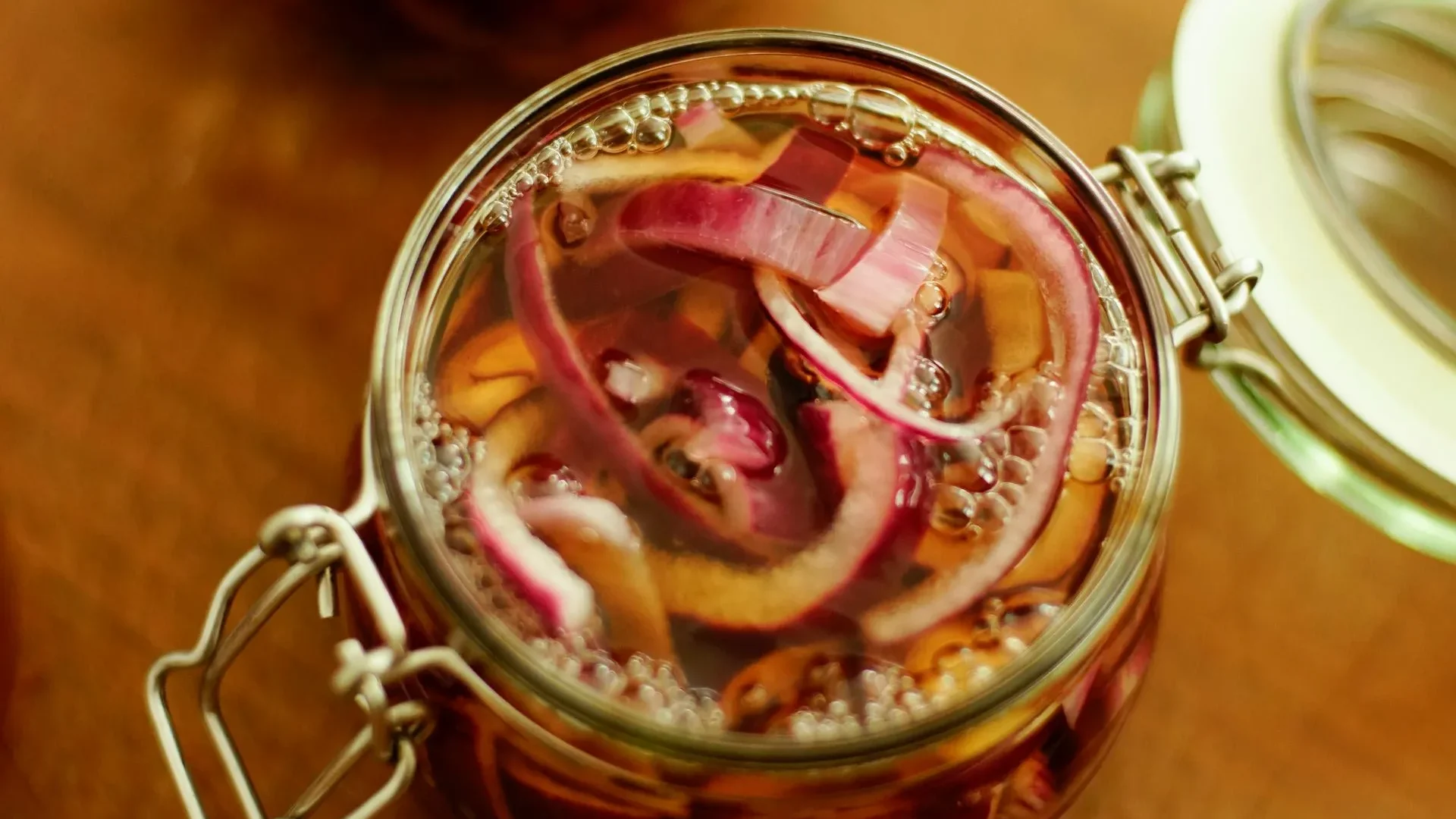 A glass jar of bubbling sauerkraut with brine, visually defining what is a fermented food: a preserved food transformed by beneficial microbes.