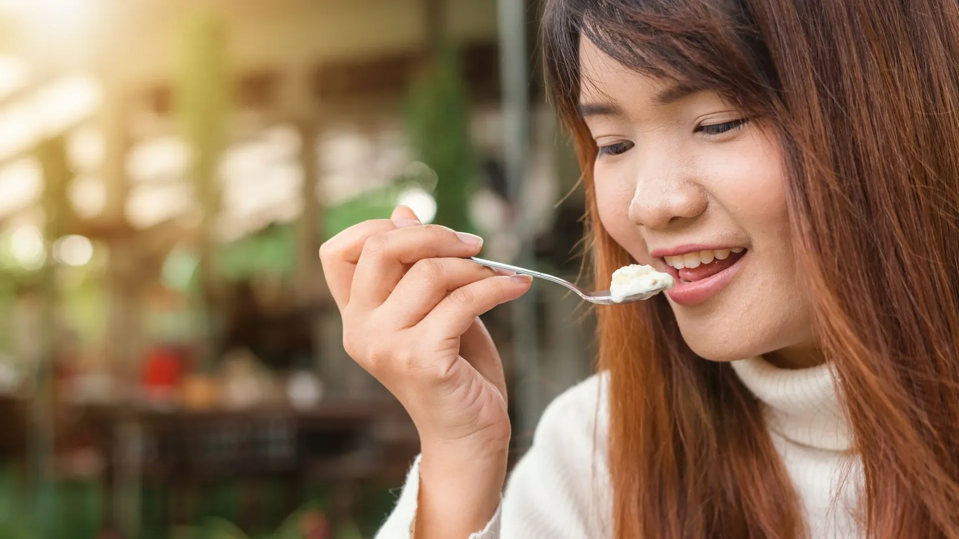 Person smiling while preparing a meal with multiple fermented foods, concluding the simple answer to what is a fermented food and its place in a healthy diet.