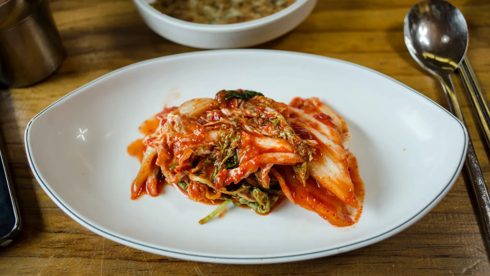 Fresh kimchi ingredients—napa cabbage, chili, garlic, and ginger—alongside a fermentation jar, explaining why kimchi matters for gut health and its probiotic richness.